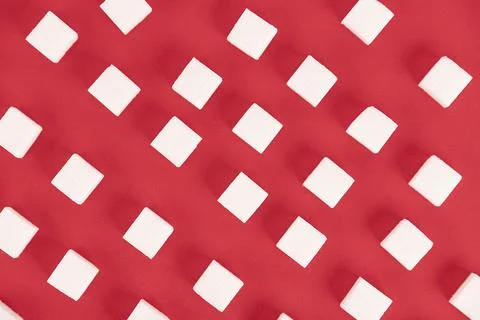 Background, cubes of sugar on a red background. Stock Photos