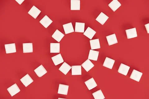 Background, cubes of sugar on a red background. Stock Photos