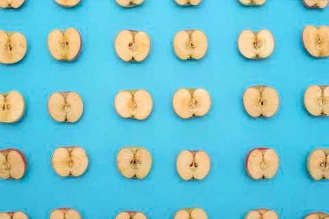 Background of cut in half apples on blue background Stock Photos