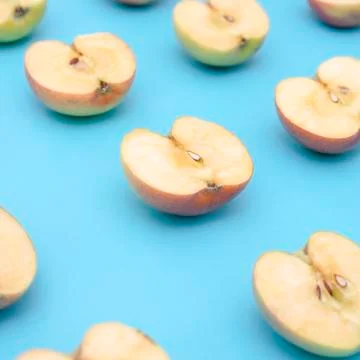 Background of cut in half apples on blue background Stock Photos