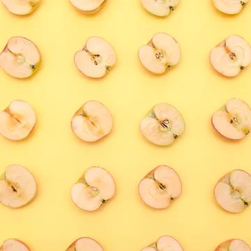 Background of cut in half apples on yellow background Stock Photos