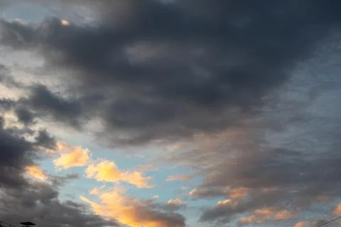 Background of dark clouds before a thunder-storm. Dramatically illuminated cl Stock Photos