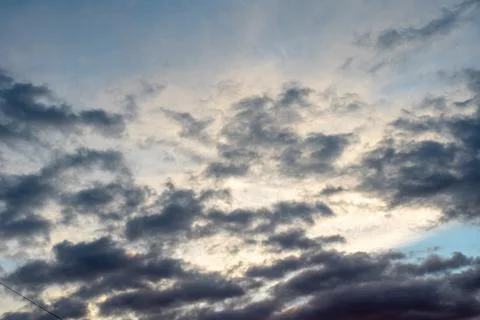 Background of dark clouds before a thunder-storm. Dramatically illuminated cl Stock Photos