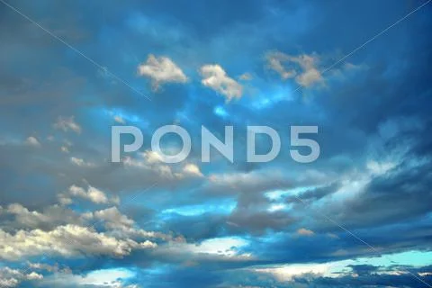 Background of deep blue sky with fluffy clouds Stock Photos