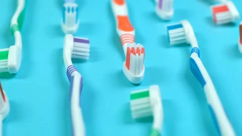 Background dental toothbrushes of different colors on a blue background top view Stock Footage 224646970