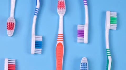 Background dental toothbrushes of different colors on a blue background top view Stock Footage 238806162