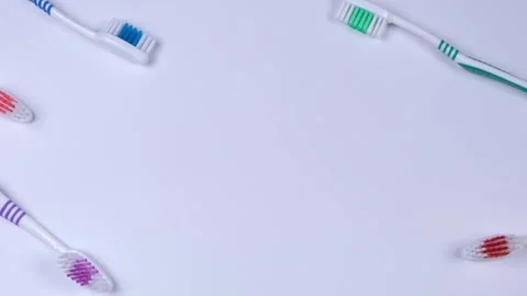 Background dental toothbrushes of different colors on a blue background top view Stock Footage 246039339