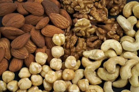 Background from different types of nuts. almonds, cashews, hazelnuts. Stock Photos