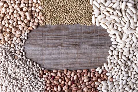Background of distant legumes forming a circle on wooden board Stock Photos