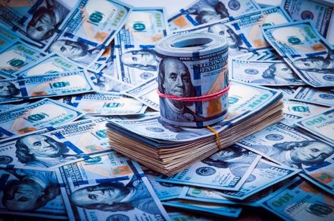 Background from dollars. Notes of one hundred American dollars are scattered Stock Photos