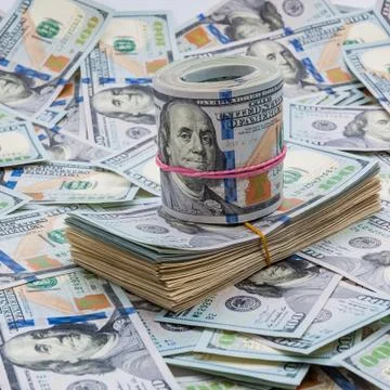 Background from dollars. Notes of one hundred American dollars are scattered Stock Photos
