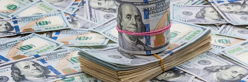 Background from dollars. Notes of one hundred American dollars are scattered Stock Photos