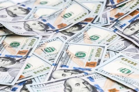 Background from dollars. Notes of one hundred American dollars are scattered Stock Photos