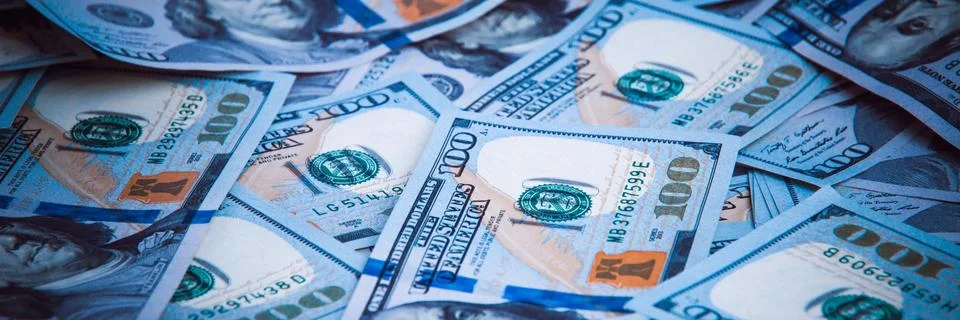 Background from dollars. Notes of one hundred American dollars are scattered Stock Photos