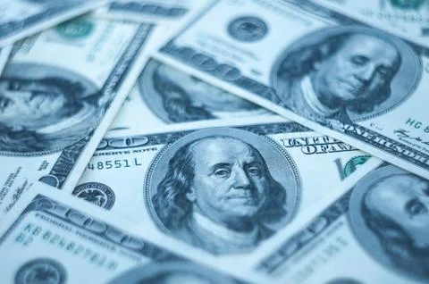 Background from dollars. Notes of one hundred American dollars are scattered Stock Photos