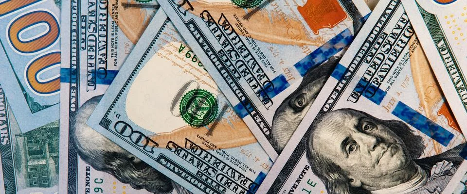Background from dollars. Notes of one hundred American dollars are scattered  Stock Photos