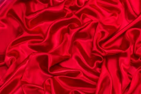 Background of draped red silk fabric. Creases and creases in the fabric. Conc Stock Photos