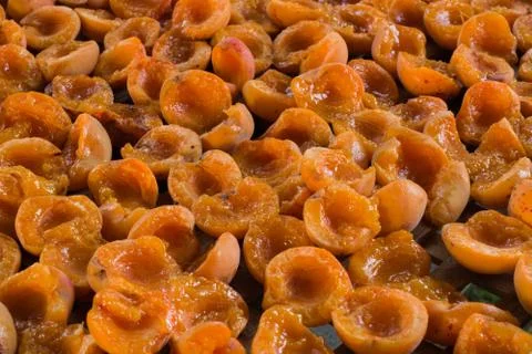 Background of dried  half apricots. Close-up of sliced fruit on wooden tray. Stock Photos