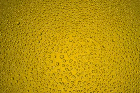 Background from drops of the different size on yellow glass Stock Photos