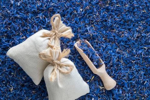 Background of dry blue cornflower, two sachet bags and wooden scoop. Top view Stock Photos