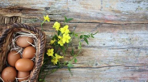 Background easter. A basket with eggs stands on a wooden rustic background... Stock Photos