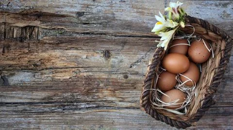 Background easter. A basket with eggs stands on a wooden rustic background... 스톡 사진