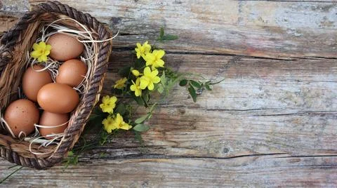 Background easter. A basket with eggs stands on a wooden rustic background... Stock Photos