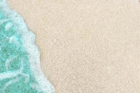 Background with emerald wave on white sand. Фото