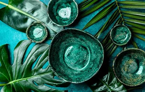 Background with empty green plates over tropical palm tree leaves and monstera Stock Photos