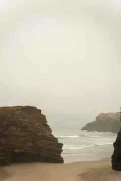 Background of an empty sand and rock beach during a summer storm Stock Photos