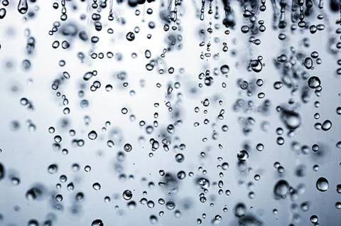 Background of falling drops on a blue background. it raining. Stock Photos