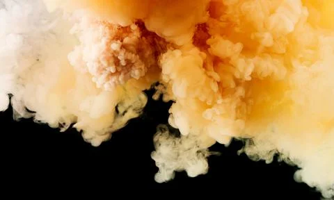 Background of falling white and yellow paint in water Stock Photos