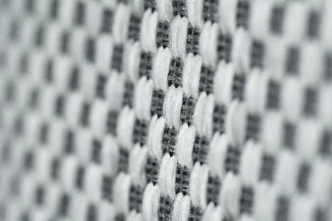The background features a macrotexture made of white-and-gray woven fabric. Stock Photos