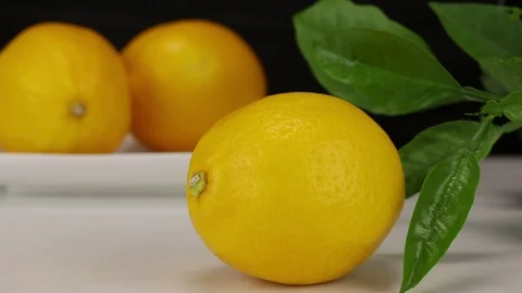 In the background female hands put two lemons Stock Footage 122986585