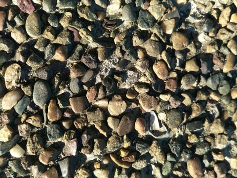 Background of fine coastal pebbles pressed tightly brown shades Stock Photos