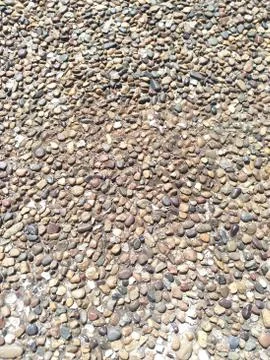 Background of fine coastal pebbles pressed tightly brown shades Stock Photos