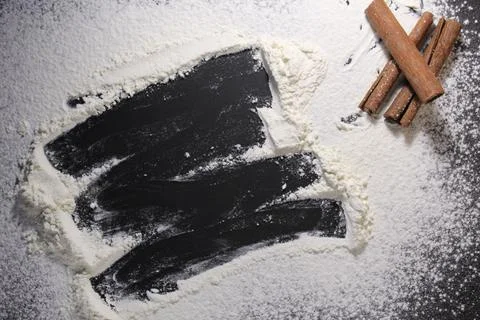 Background flour black background with cinnamon sticks spears copy space Stock Photos