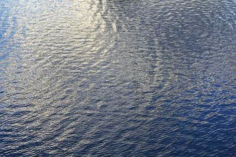 Background in the form of a calm water surface. Stock Photos