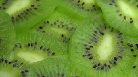 Background in the form of sliced kiwi spins, juicy green kiwi fruit or chinese Stock Footage 164693984
