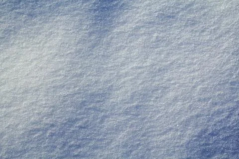 Background in the form of a wavy surface of snow in a field in natural daylig Stock Photos