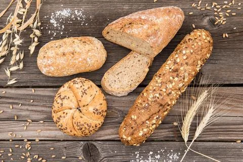 Background of fresh bread and bakery on an old vintage planked wood table. Stock Photos