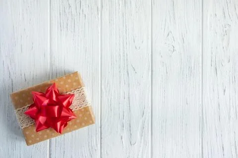 Background with a gift box. Box with a present boxes on a wooden background. Stock Photos