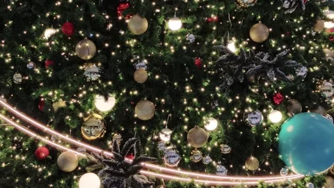 In the background, a glowing Christmas tree decorated with red and gold bau.. Stock Footage 322210452
