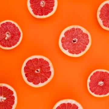 Background of grapefruit split in half and arranged on an orange background Stock Photos