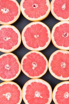 Background of grapefruits split in half on a black background Stock Photos