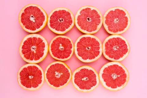 Background of grapefruits split in half on a pink background Stock Photos