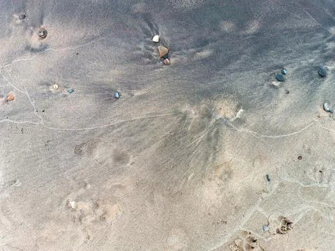 Background of gray and black sand on the shore of Lake Baikal Stock Photos