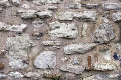 Background of a gray wall made of large and small white rough limestones Stock Photos