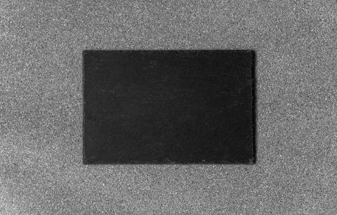 Background of grey stone texture and pattern with black slate piece. Stock Photos