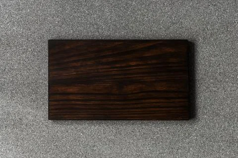 Background of grey stone texture and pattern with brown wooden cutting board. Stock Photos